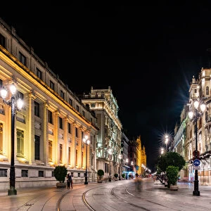 The lights of Sevilles buildings at night looking down the Avenida de la