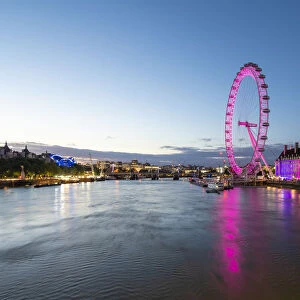 The London Eye lit up pink during blue hour, and River Thames, London, England