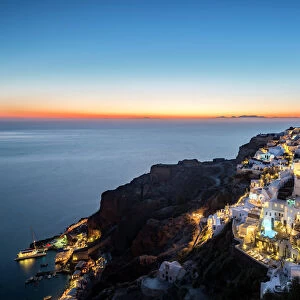 Long exposure sunset view over the whitewashed buildings and windmills of Oia, Santorini