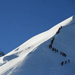 Long line of climbers on summit ridge of Mont Blanc, 4810m, Chamonix, French Alps