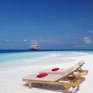 Lounge chairs on beach and yacht, Maldives, Indian Ocean, Asia