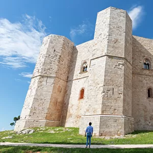Man admires the octagonal castle of Castel del Monte in a clear sunny day, UNESCO World Heritage Site, Apulia, South of Italy, Italy, Europe