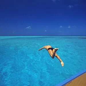 Man jumping into tropical sea from deck, Maldives, Indian Ocean, Asia
