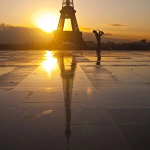 A man playing a trumpet in front of the Eiffel Tower, Paris, France, Europe