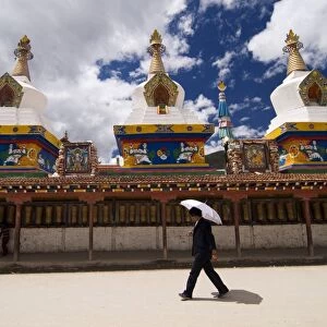 Man with umbrella at temple, Yushu, Qinghai, China, Asia