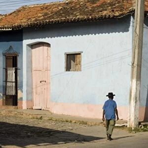 A man walking past colourfully painted houses in Trinidad, UNESCO World Heritage Site