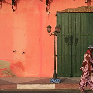 Man walking past a pink house, St. Louis, Senegal, West Africa, Africa