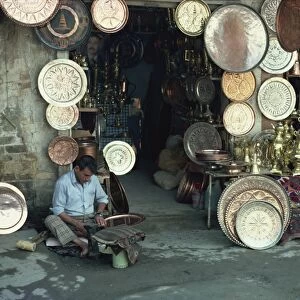 Man working on copper plate outside a copper souk, Baghdad, Iraq, Middle East