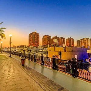 Marina corniche promenade at night in Porto Arabia at the Pearl-Qatar, with residential