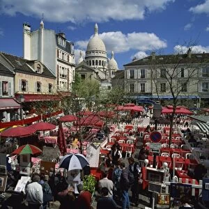 Market stalls and outdoor cafes in the Place du Tertre, with the Sacre Coeur behind