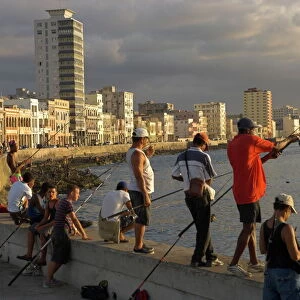 Men fishing at sunset, Avenue Maceo, El Malecon, Havana, Cuba, West Indies