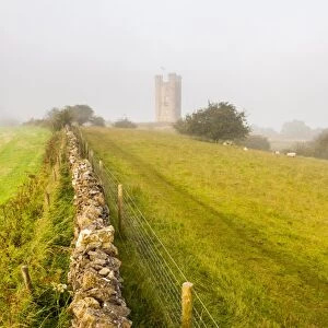 Misty sunrise at Broadway Tower, a National Trust property at Broadway, The Cotswolds, Gloucestershire, England, United Kingdom, Europe