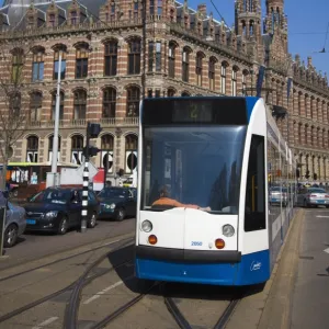 Modern tram with the Magna Plaza building behind, Amsterdam, Netherlands, Europe