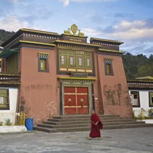 Monk walking past entrance to main monastery building, Rumtek Gompa Complex