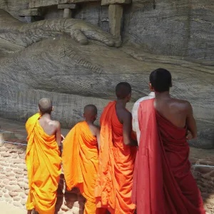 Monks looking at reclining Buddha statue, Gal Vihara, Polonnaruwa, UNESCO World Heritage Site, North Central Province, Sri Lanka, Asia