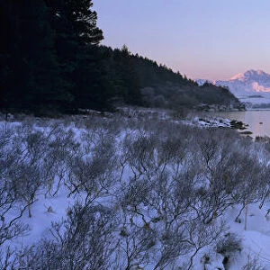 Mount Snowdon in snow at sunrise with frozen LLynnau Mymbyr lake, Capel Curig