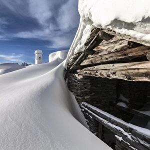 A mountain hut emerging from thick snow after a heavy snowfall in the Alpe Scima, Valchiavenna, Lombardy, Italy, Europe