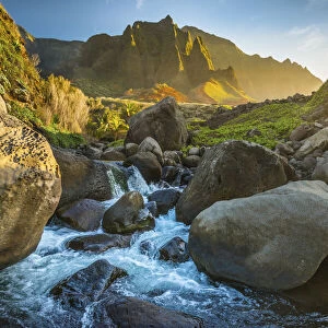 Mountain stream flows from the NaPali Cliffs in the background, Hawaii