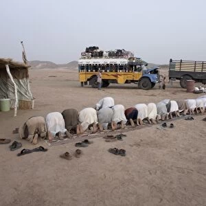 Muslims stop in the Nubian Desert for evening prayers