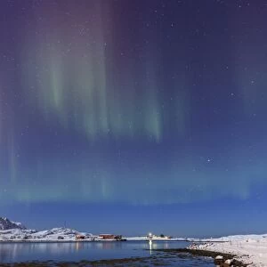 Northern lights (Aurora Borealis) on the snowy peaks reflected in the cold sea, Volanstinden
