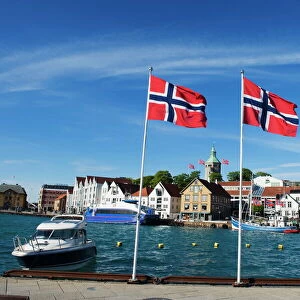 Norwegian flags and historic harbour warehouses, Stavanger, Norway, Scandinavia, Europe