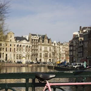 Old pink bicycle by the Herengracht canal, Amsterdam, Netherlands, Europe