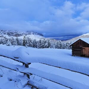Old snow-covered huts during twilight, Erbe Pass, Funes Valley, Sudtirol (South Tyrol)