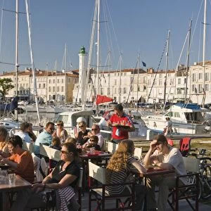 Open-air restaurant seating next to the ancient harbour at La Rochelle
