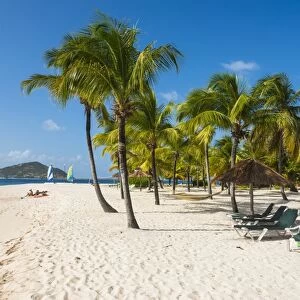 Palm fringed white sand beach on Palm Island with Union Island in the background, the Grenadines, St. Vincent and the Grenadines, Windward Islands, West Indies, Caribbean, Central America