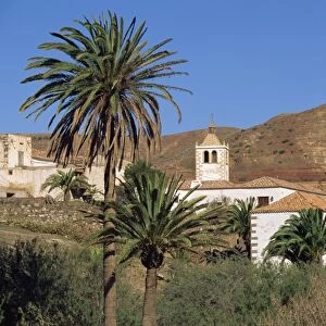 Palm trees, houses and church at Betancuria, on Fuerteventura in the Canary Islands