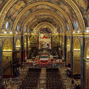 Panoramic interior view of Roman Catholic St. John Co-Cathedral with golden Maltese cross symbols on arches, Valletta, Malta, Europe