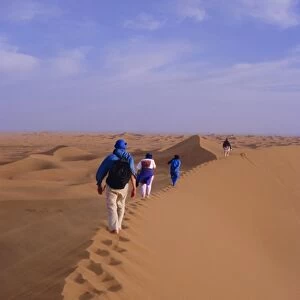 Party of trekkers on top of dunes at Chigaga