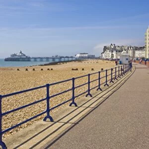 Pebble beach and groynes, hotels on the seafront promenade, Eastbourne pier in the distance