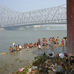 People bathing in the Hooghly River from a ghat near the Howrah Bridge, Kolkata (Calcutta), West Bengal, India, Asia