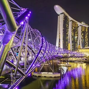 People strolling on the Helix Bridge towards the Marina Bay Sands and ArtScience Museum at night