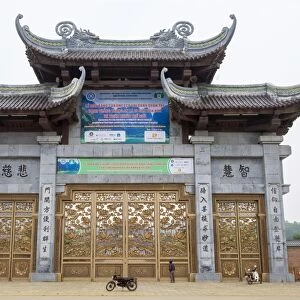 A person looking up at Bai Dinh Temple (Chua Bai Dinh) gate, Gia Vien District, Ninh Binh Province