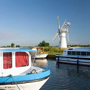 Pleasure boats moored beside Thurne windmill, Norfolk Broads, Thurne, Norfolk