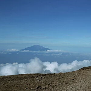 Porter with Mount Meru in background, Kilimanjaro National Park, Tanzania