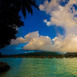 Rainbow arcing over the overwater bungalows, Le Taha a Resort, Tahiti, French Polynesia