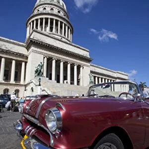 Red vintage American car parked opposite The Capitolio, Havana Centro, Havana, Cuba, West Indies, Central America