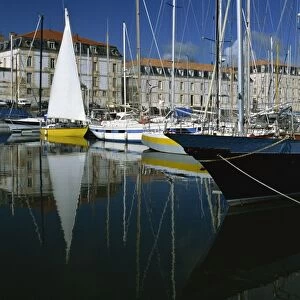 Reflections of boats in the marina with the naval storehouse, (Magasin aux Vivres) behind