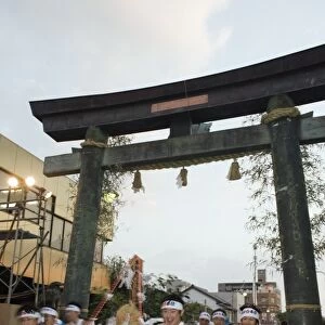 Rice bales being carried through a torii gate at Hadaka Matsuri (Naked Festival)