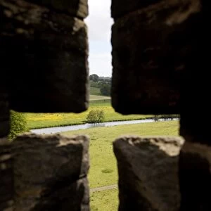 River Aln seen through arrow slit of the walls of Alnwick Castle, Northumberland