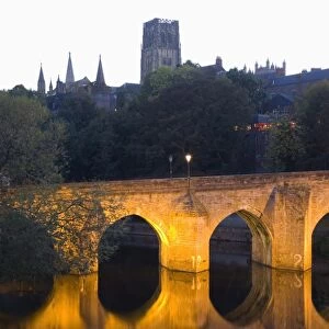 The River Wear and Elvet Bridge illuminated by night, the cathedral on hillside beyond