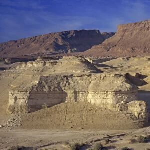 Rock cliffs and sand dunes in front of the fortress of Masada, in the Judean Desert