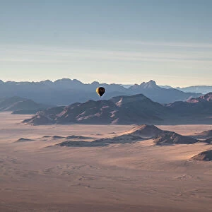 Rocky mountains, aerial view with hot air balloon flying over it, Namibia, Africa