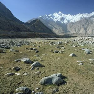 Rocky valley with snow capped mountains in the background on the Karakorum Highway on route to Pakistan, in Xinjiang Province
