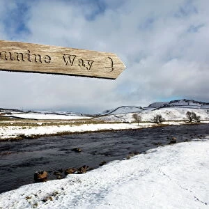 Sign for the Pennine Way walking trail on snowy landscape by the River Tees, Upper Teesdale