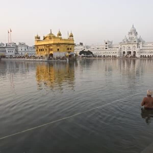 Two Sikh pilgrims bathing and praying in the early