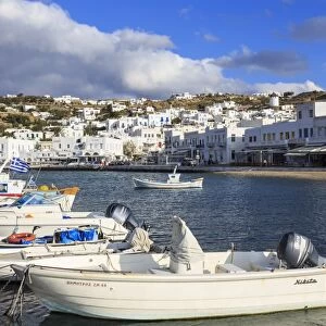 Small boats in harbour, whitewashed Mykonos Town (Chora) with windmills on hillside